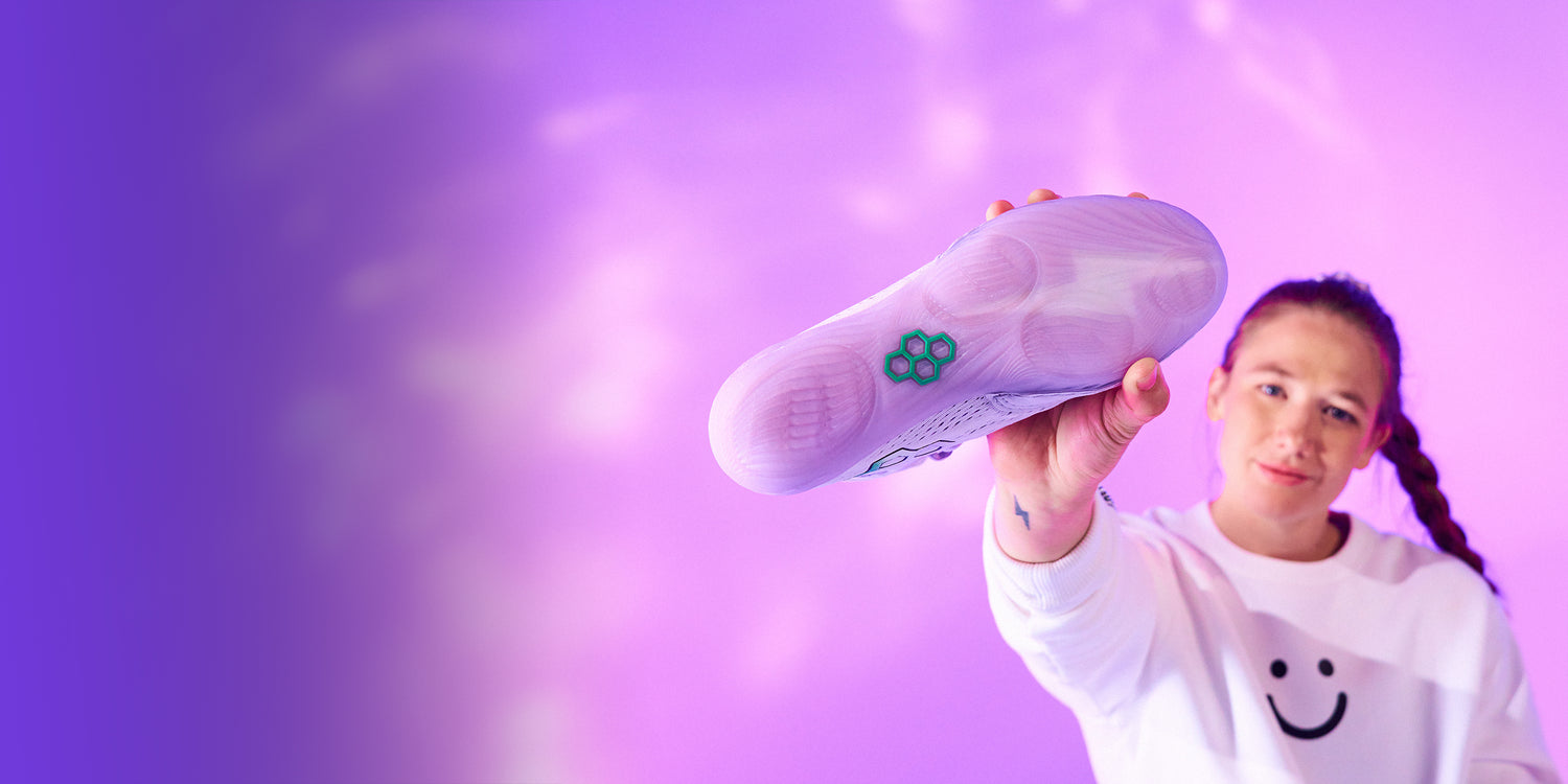 Sarah Hildebrandt holding RUDIS Hildebrandt women’s wrestling shoes Electric Lilac core colorway showcasing outsole traction and female specific design