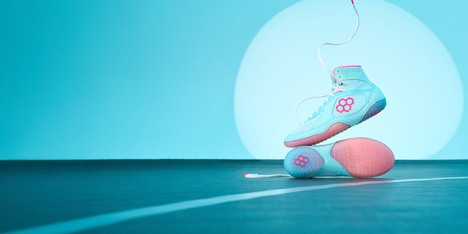 RUDIS Alpha 2.0 wrestling shoes in Cotton Candy colorway with pastel blue and pink tones, showcasing lightweight design, grip traction, and mat-ready performance