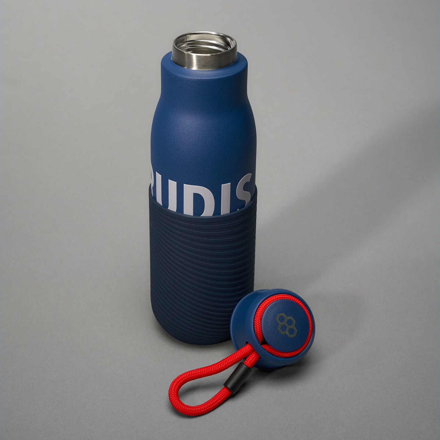 A sleek blue insulated water bottle with a textured grip and a detachable lid accessory