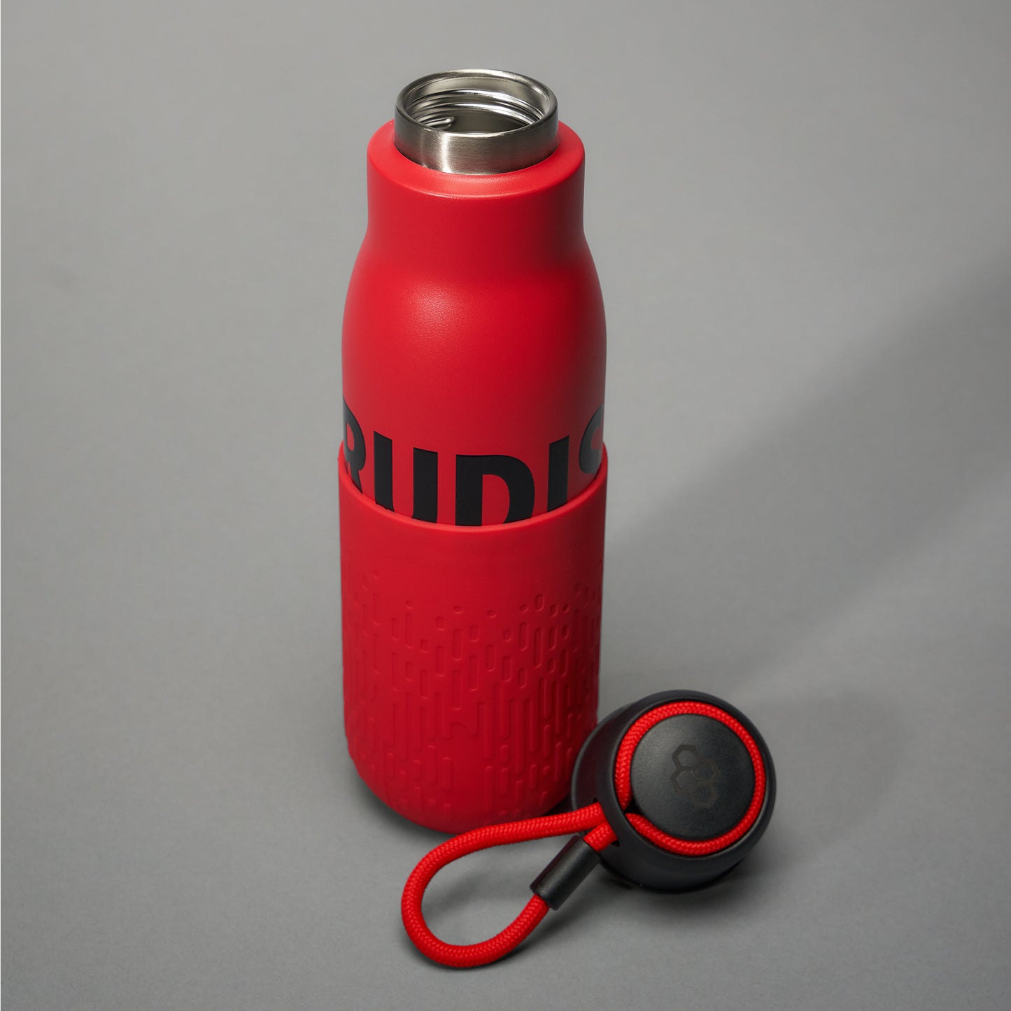 A vibrant red insulated water bottle with a textured bottom and black branding accompanied by a matching lid handle