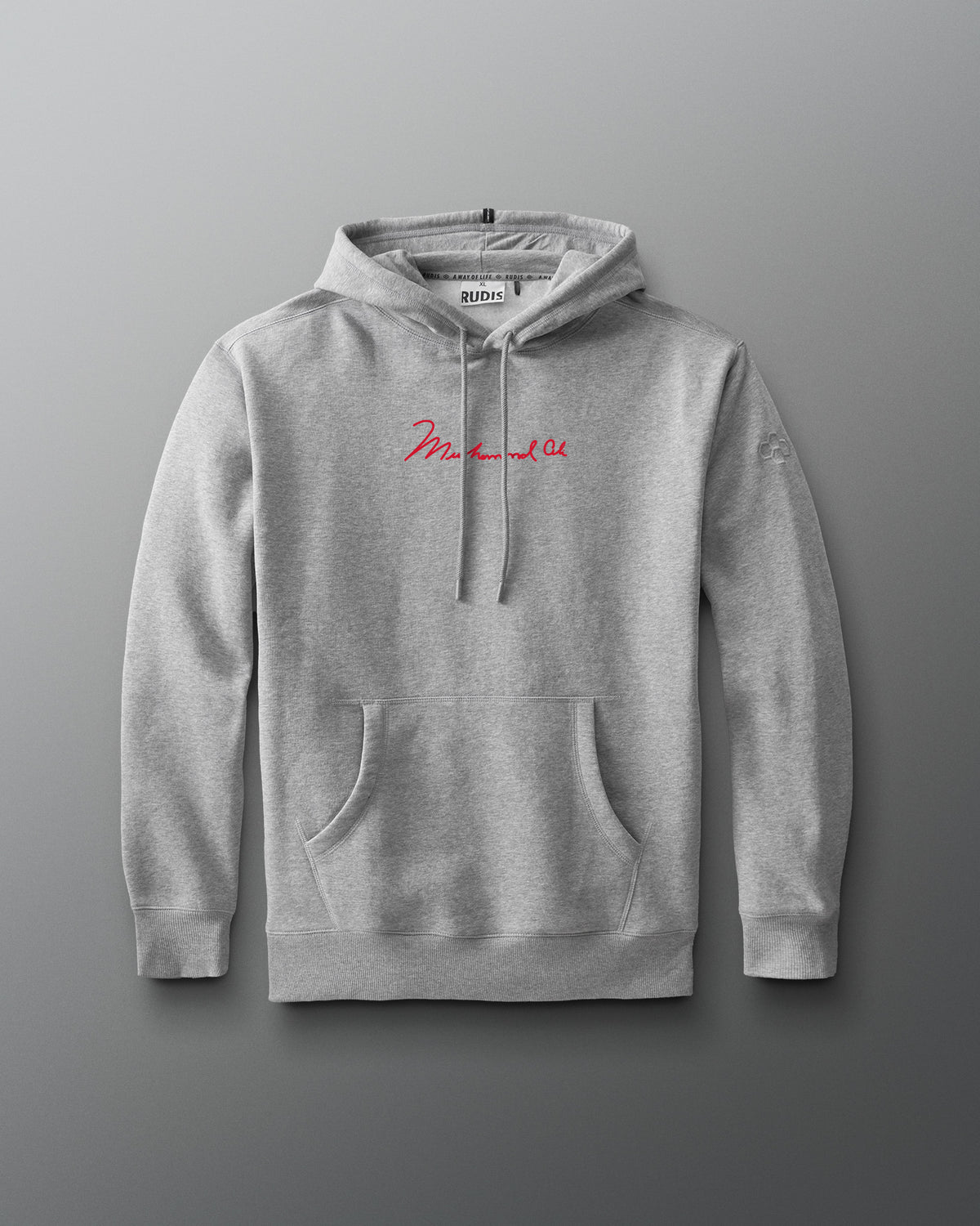 RUDIS Ali The Greatest Comfort Fleece Hoodie in gray, featuring Muhammad Ali’s signature in red across the chest, a kangaroo pocket, drawstring hood, and subtle RUDIS Hex sleeve branding.
