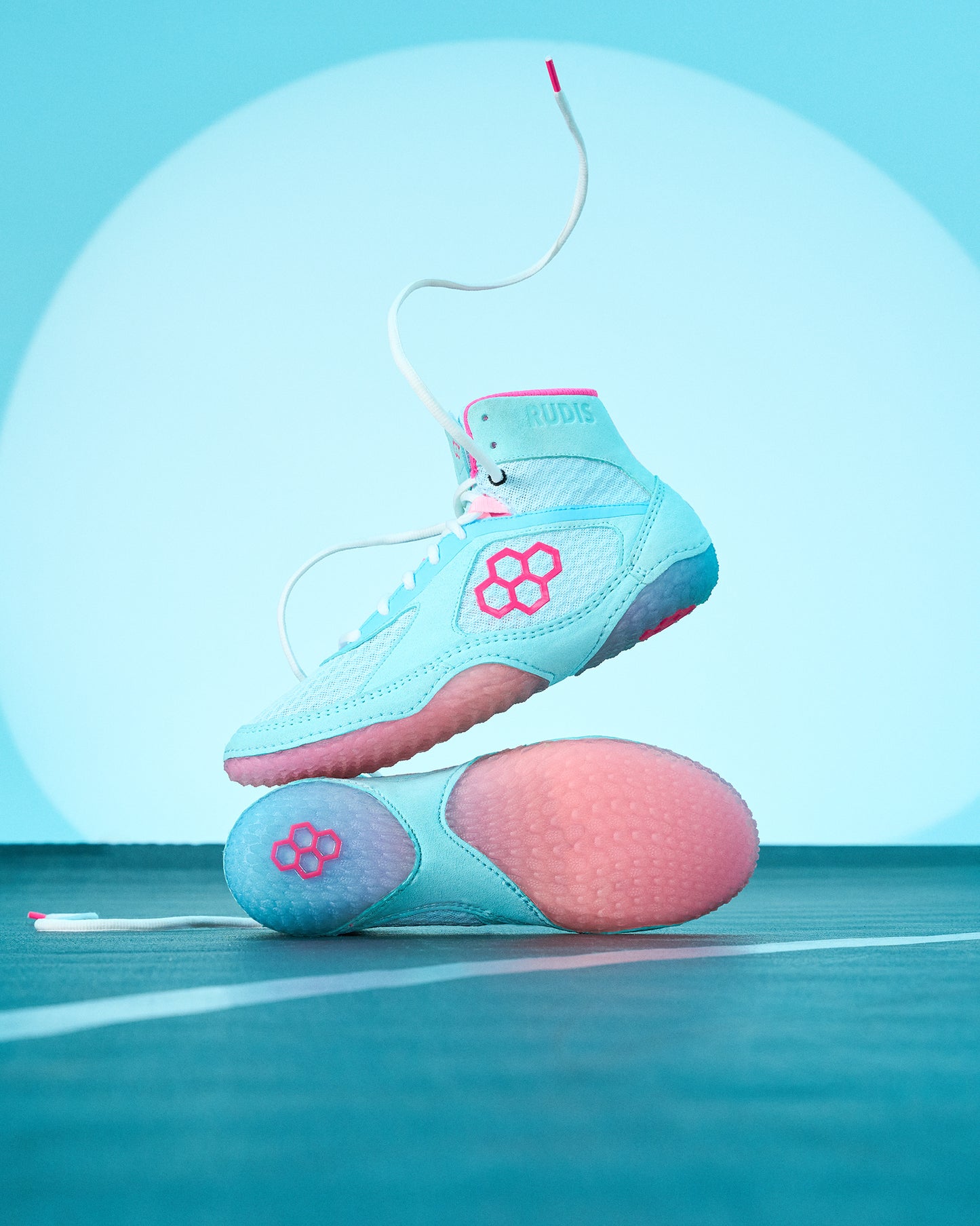 Pair of turquoise and pink high-top shoes on a blue background