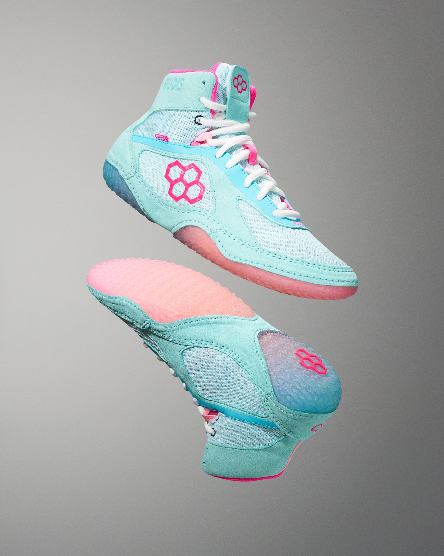 Pair of turquoise and pink Wrestling Shoe on a gray background
