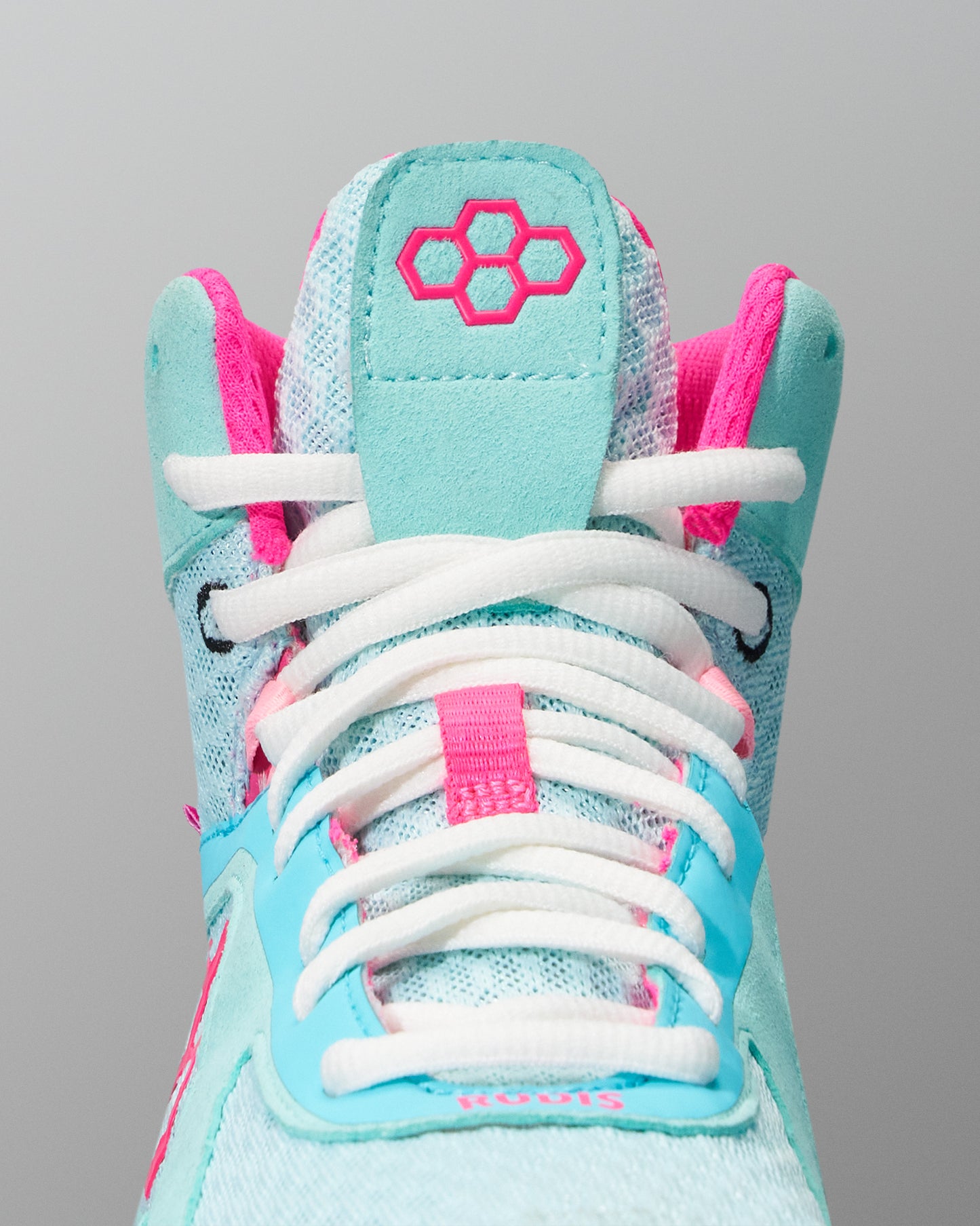 Light blue and pink Wrestling Shoe with white laces on a gray background. Pink RUDIS quad hex logo
