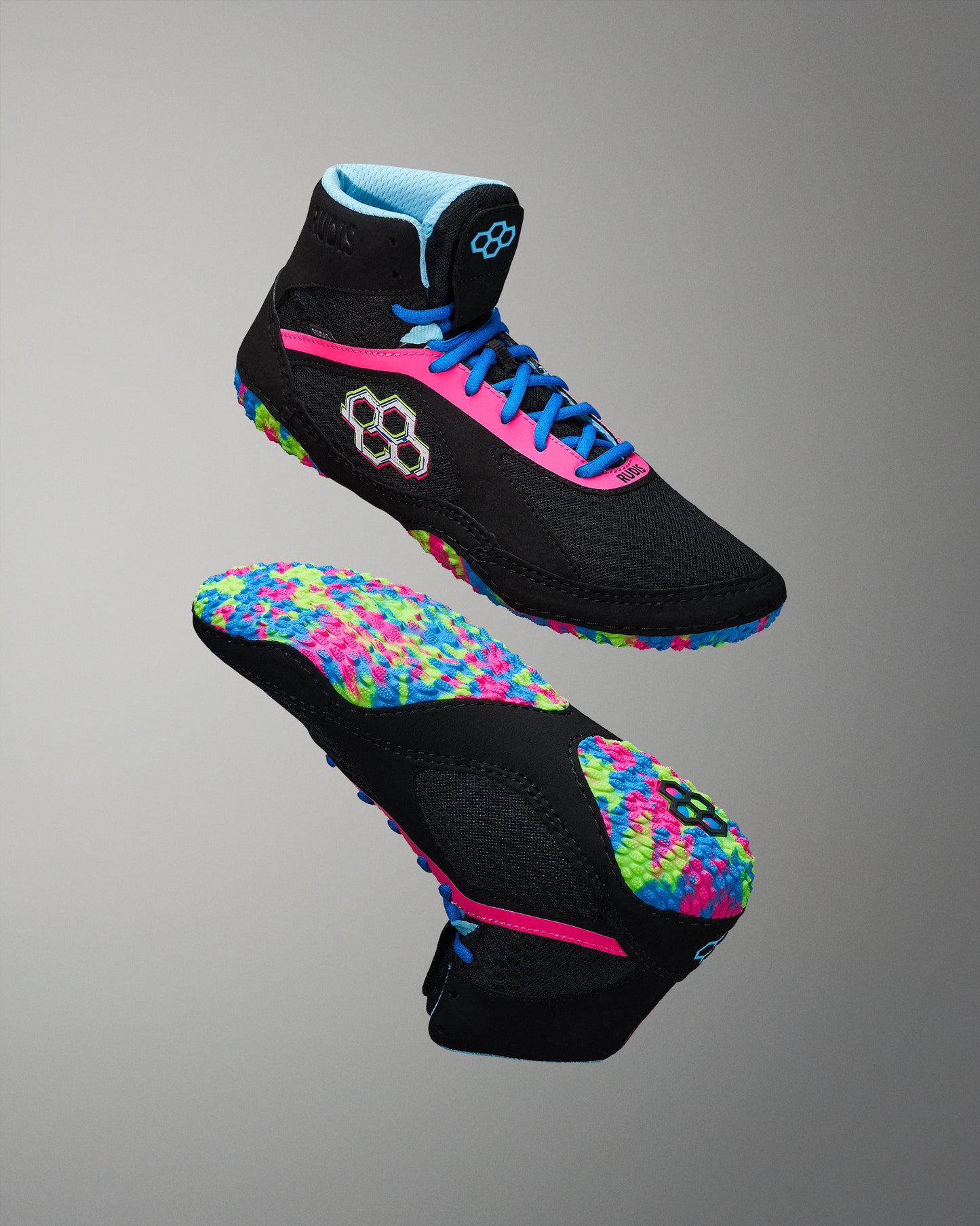 High-top athletic shoe with a black upper, bright pink laces, and a vibrant multicolored sole, designed for both comfort and style against a neutral gray background.