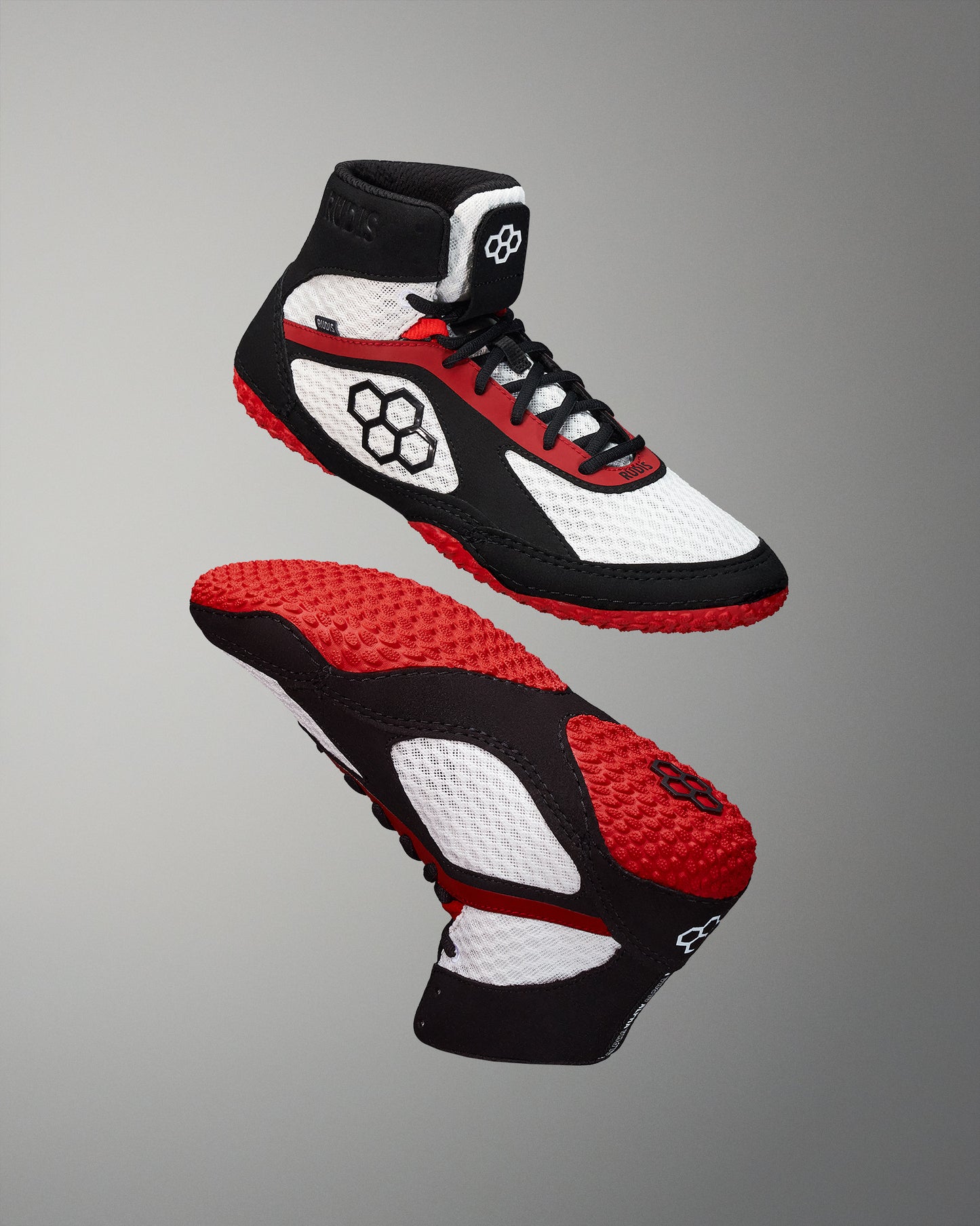 High-top athletic shoe in white, black, and red, featuring a breathable mesh upper, padded collar, and textured red and black sole designed for grip.