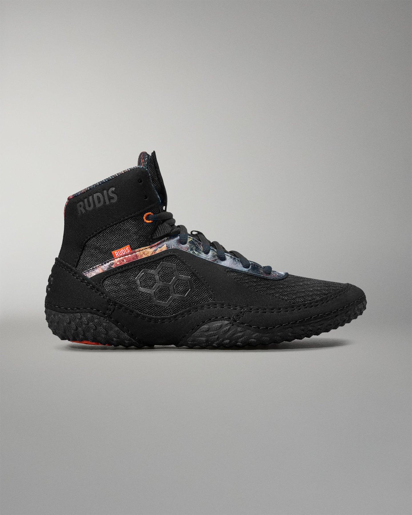 Black wrestling shoe with visible branding on a gray background