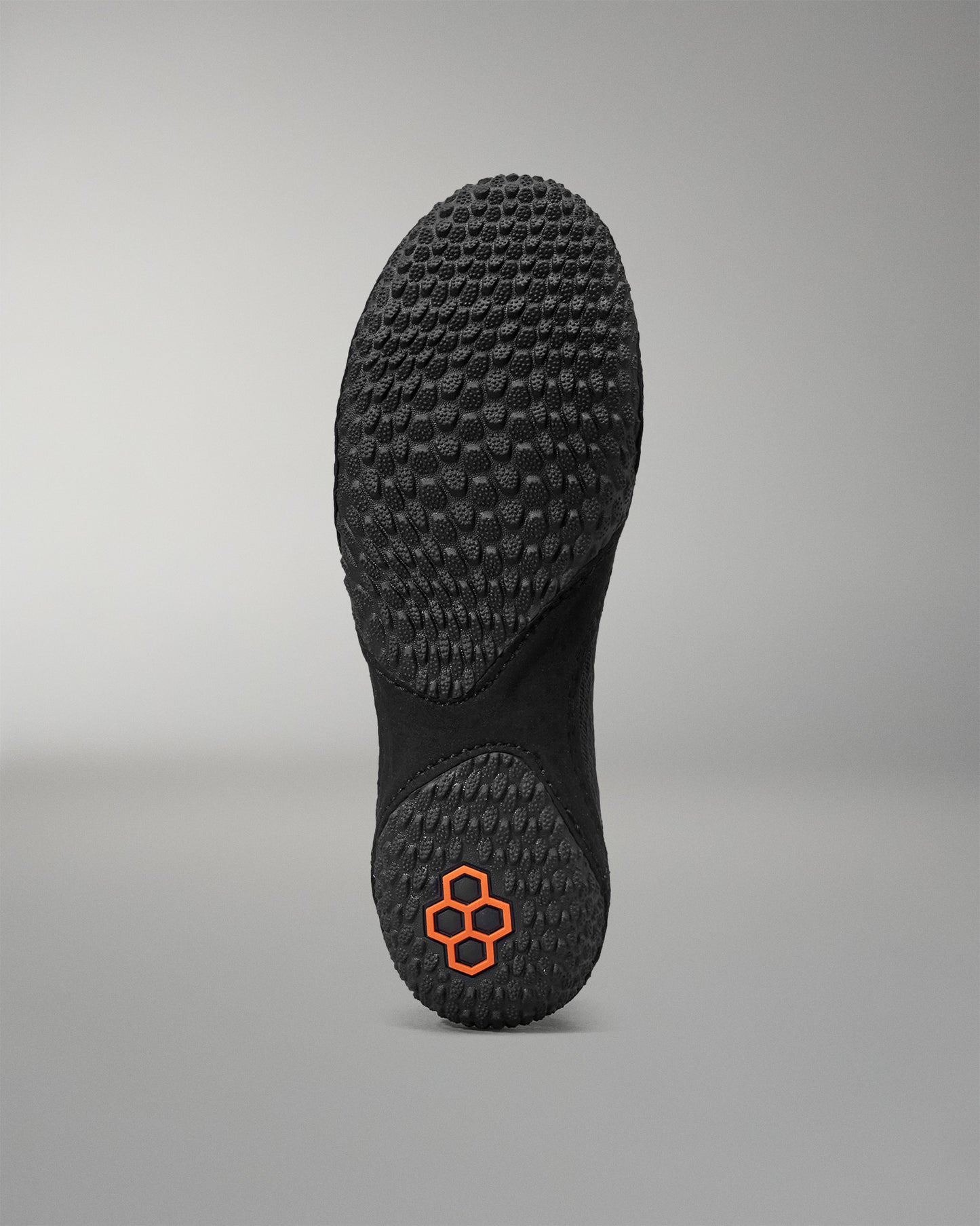Black sole of a wrestling shoe with a textured pattern on a gray background