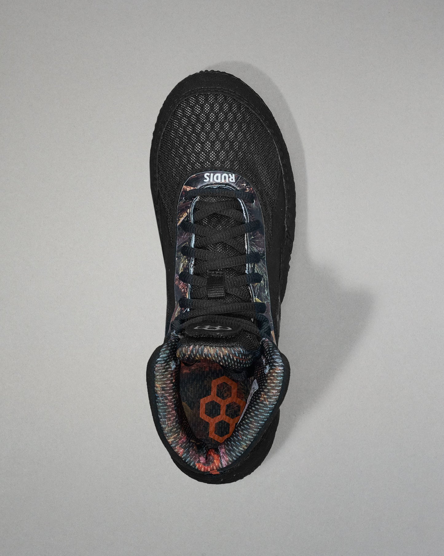Black wrestling shoe with floral pattern on a gray background