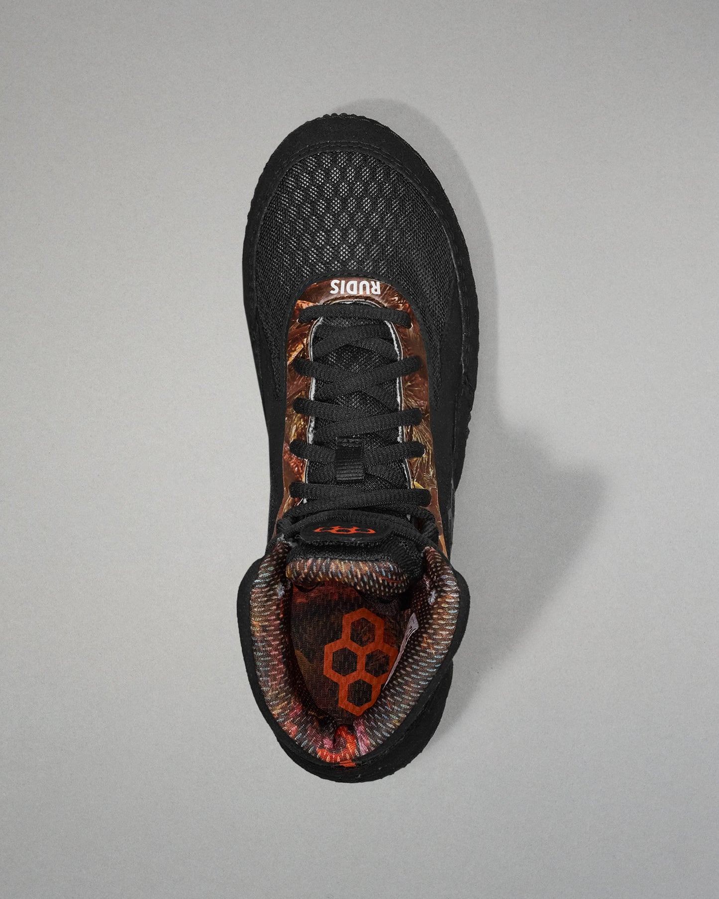 Black athletic shoe with camouflage pattern on a gray background