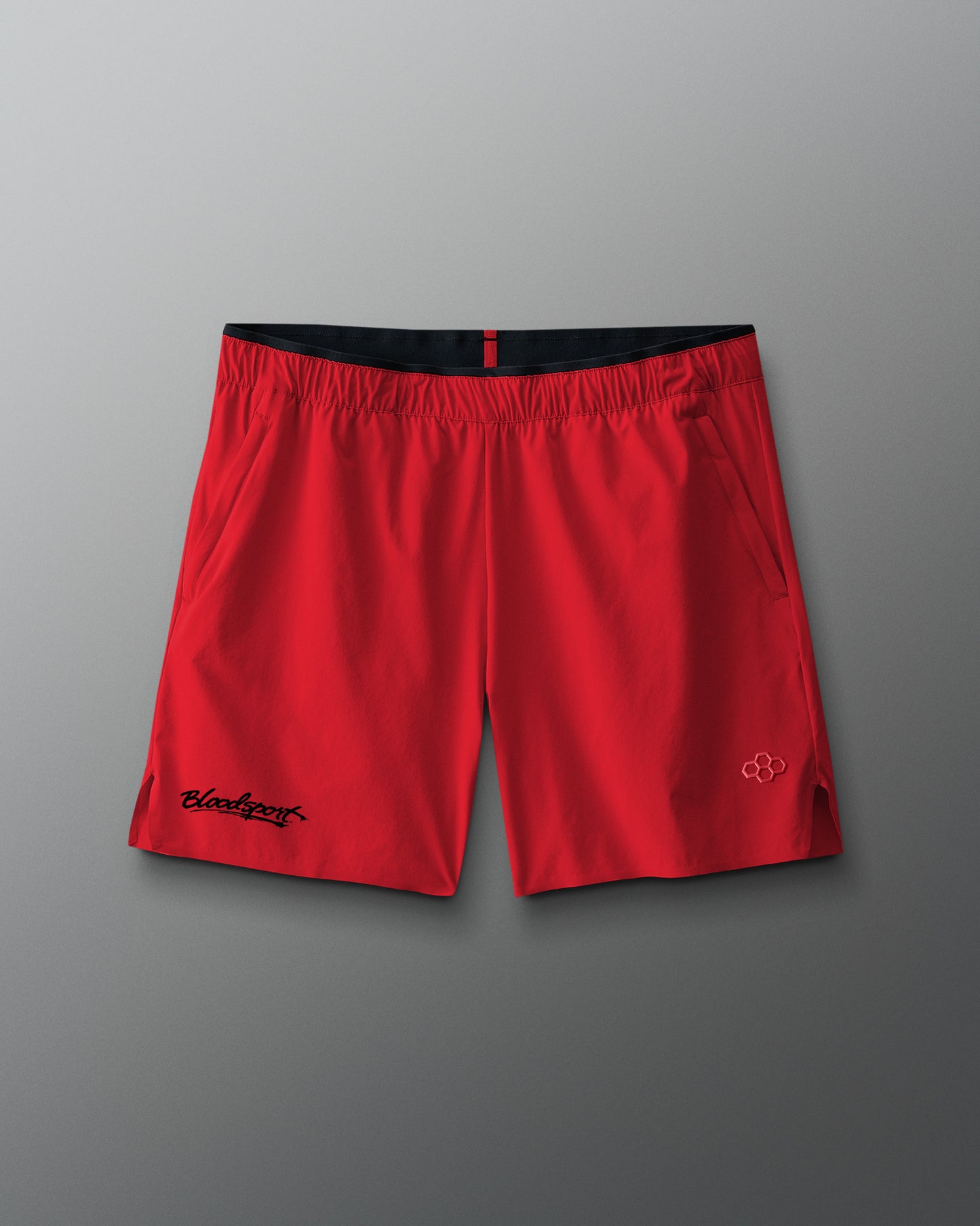 Red shorts with black waistband on a gray background