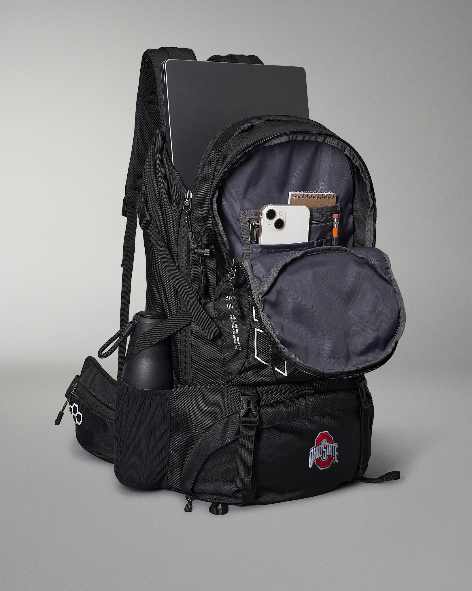 Black backpack with multiple compartments on a gray background