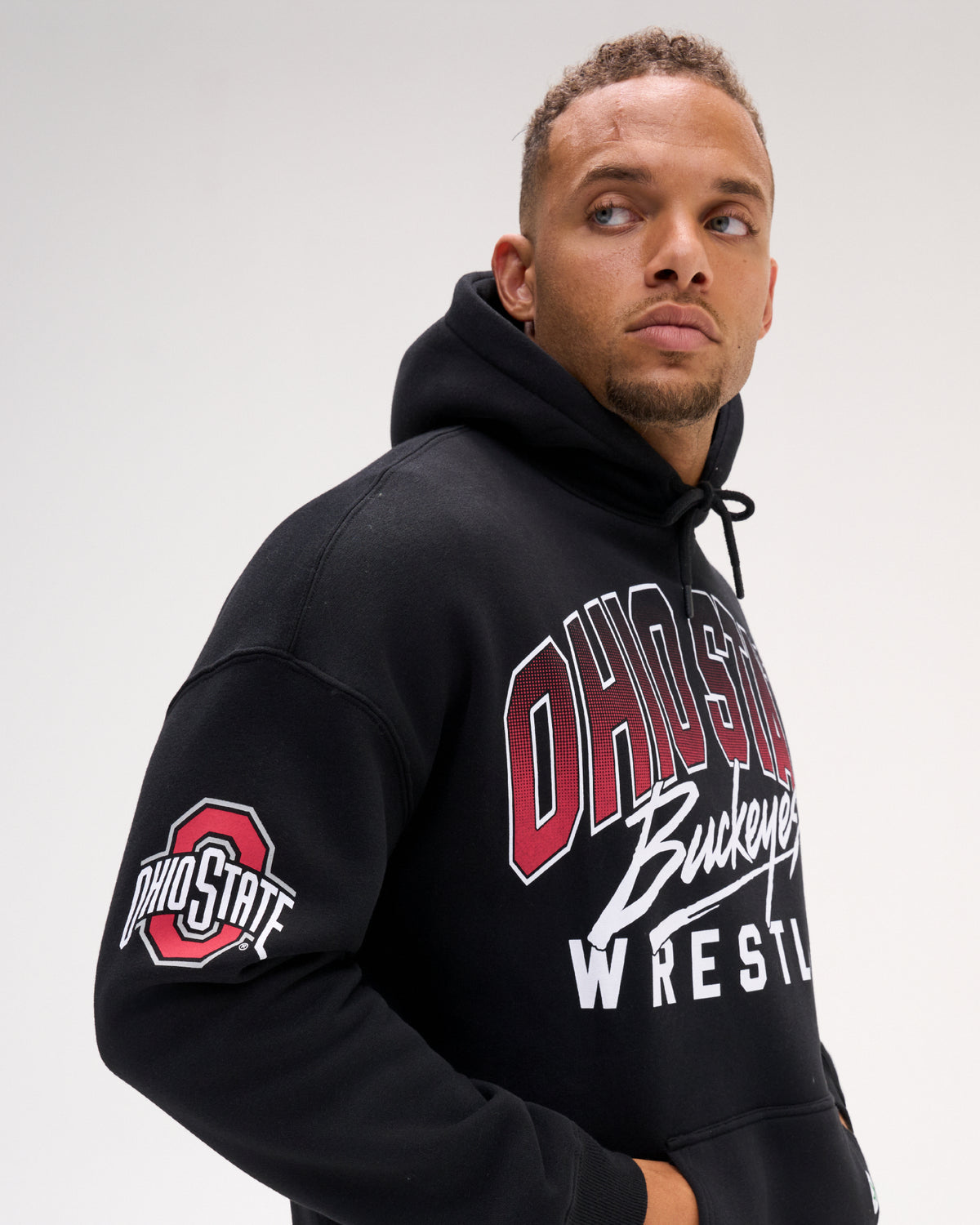 Close-up of the RUDIS Ohio State Buckeyes black fleece hoodie on a model, highlighting the Ohio State sleeve logo, Buckeyes Wrestling chest graphic and relaxed fit.