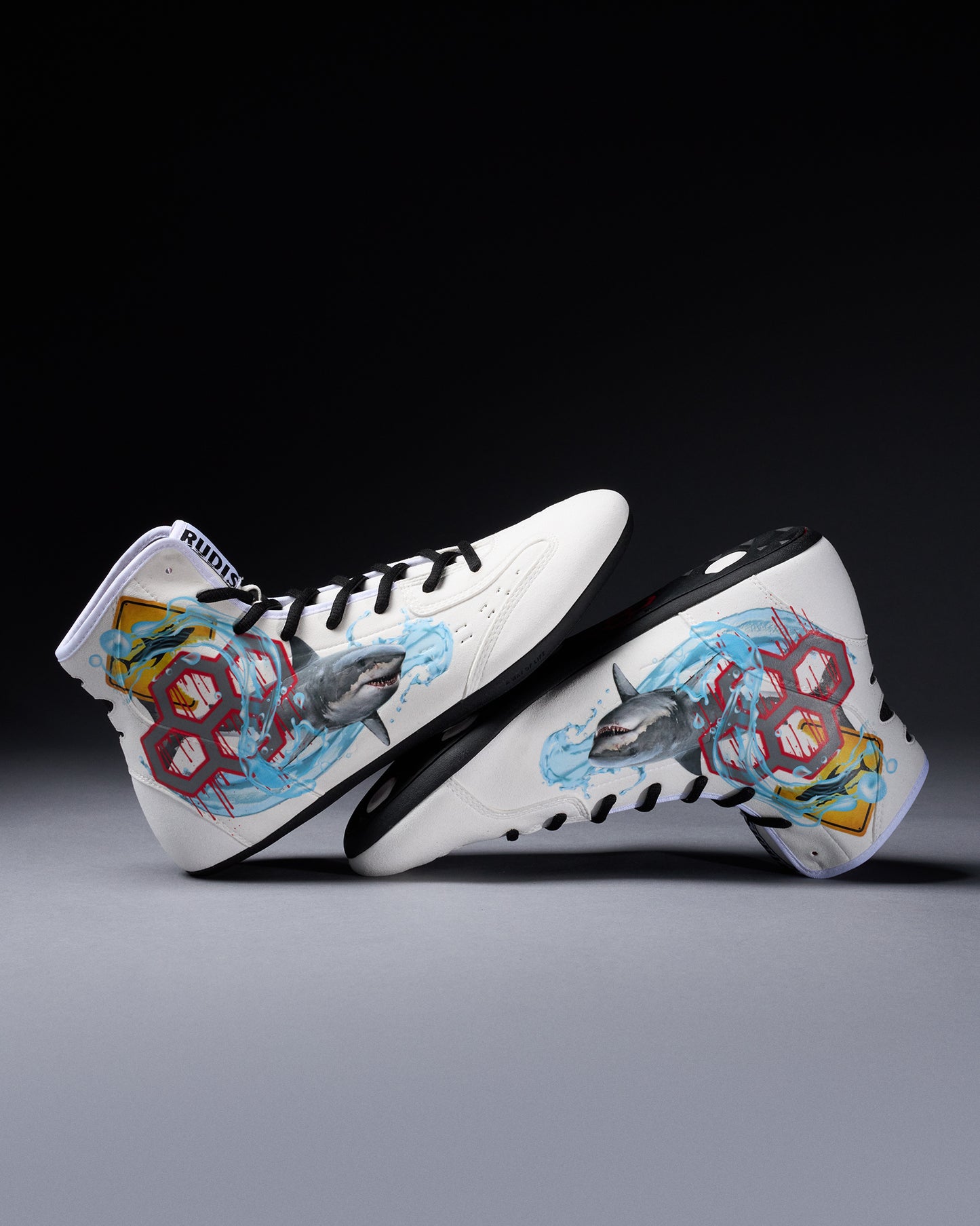 White wrestling shoes with colorful designs on a gray background