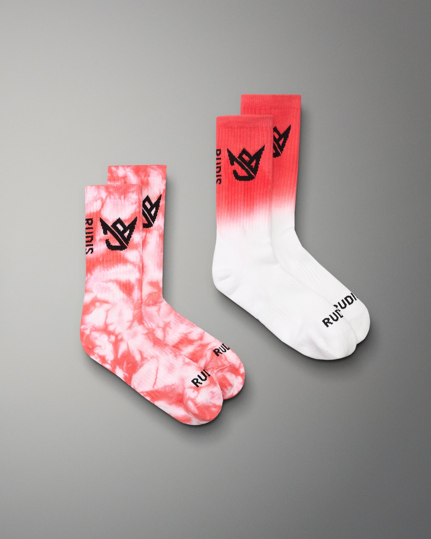 Two socks with tie-dye and gradient design on a gray background