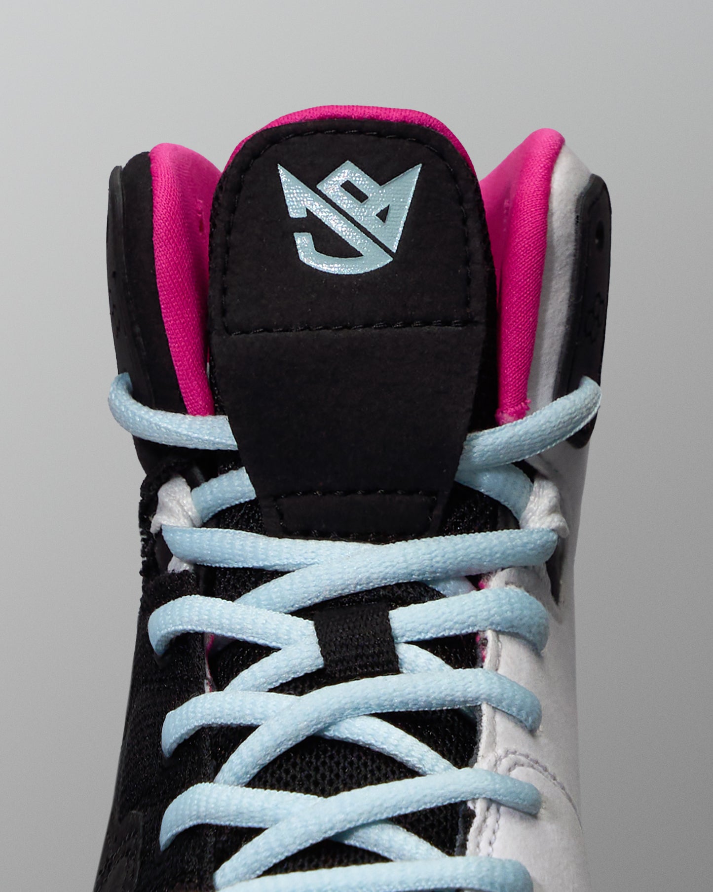 Black and pink wrestling shoe with light blue laces on a gray background