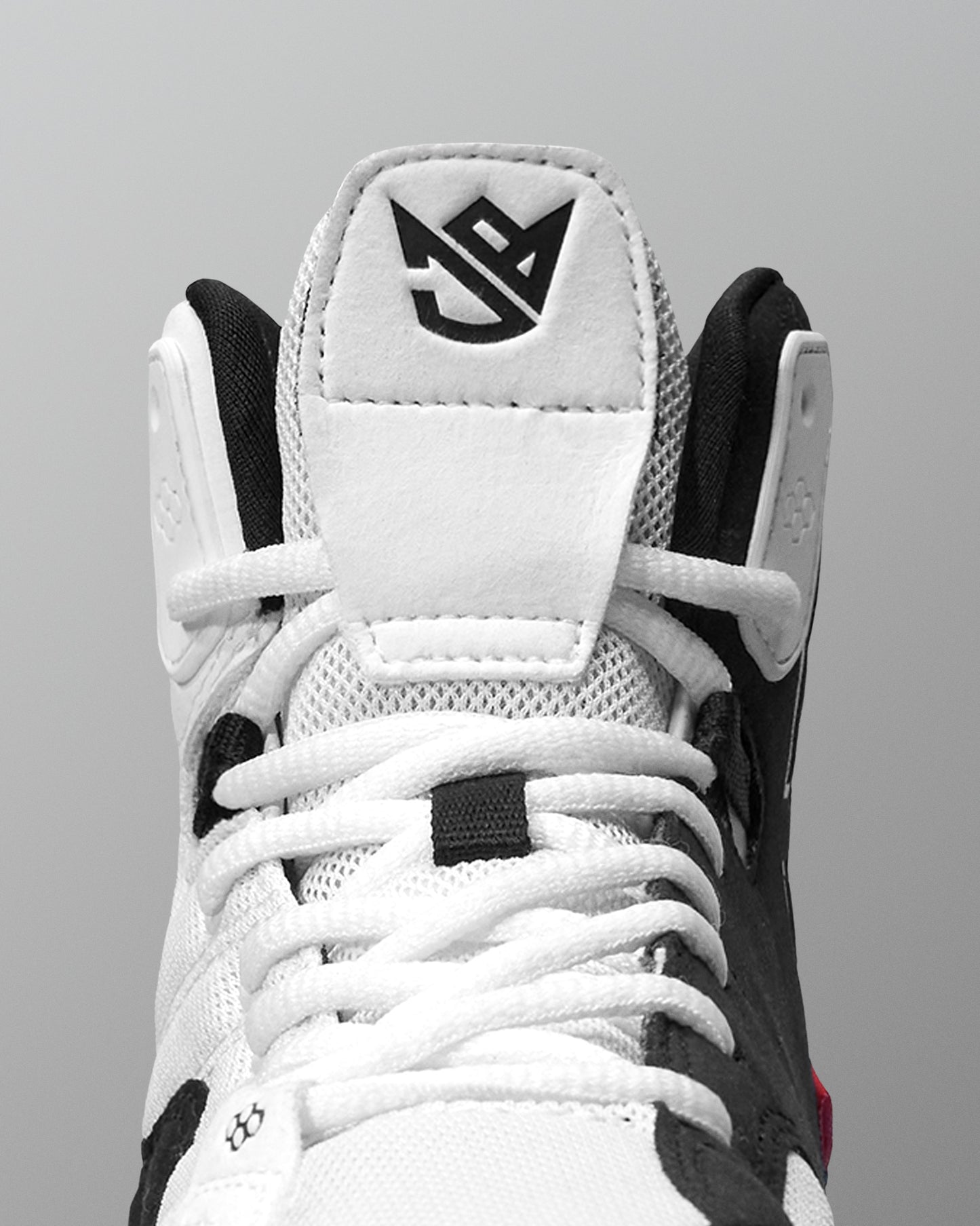 Close-up of a white and black Jordan Burroughs Wrestling shoes with a brand logo on a gray background