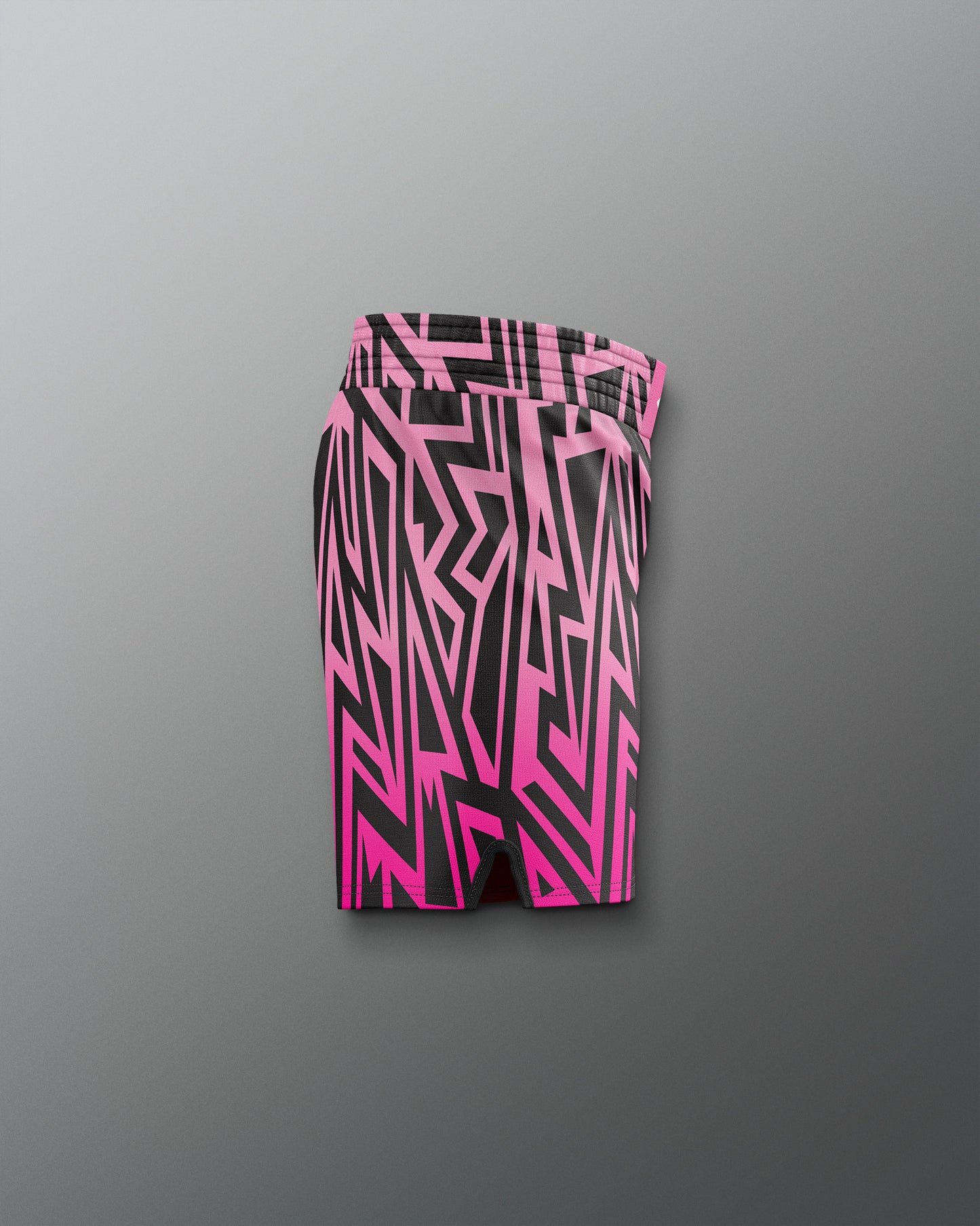 Pink and black geometric patterned shorts on a gray background