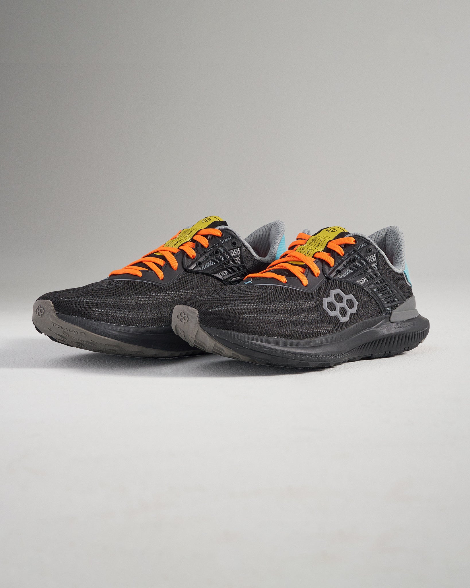Sleek black athletic shoes with vibrant orange laces and modern design elements ideal for running or casual wear