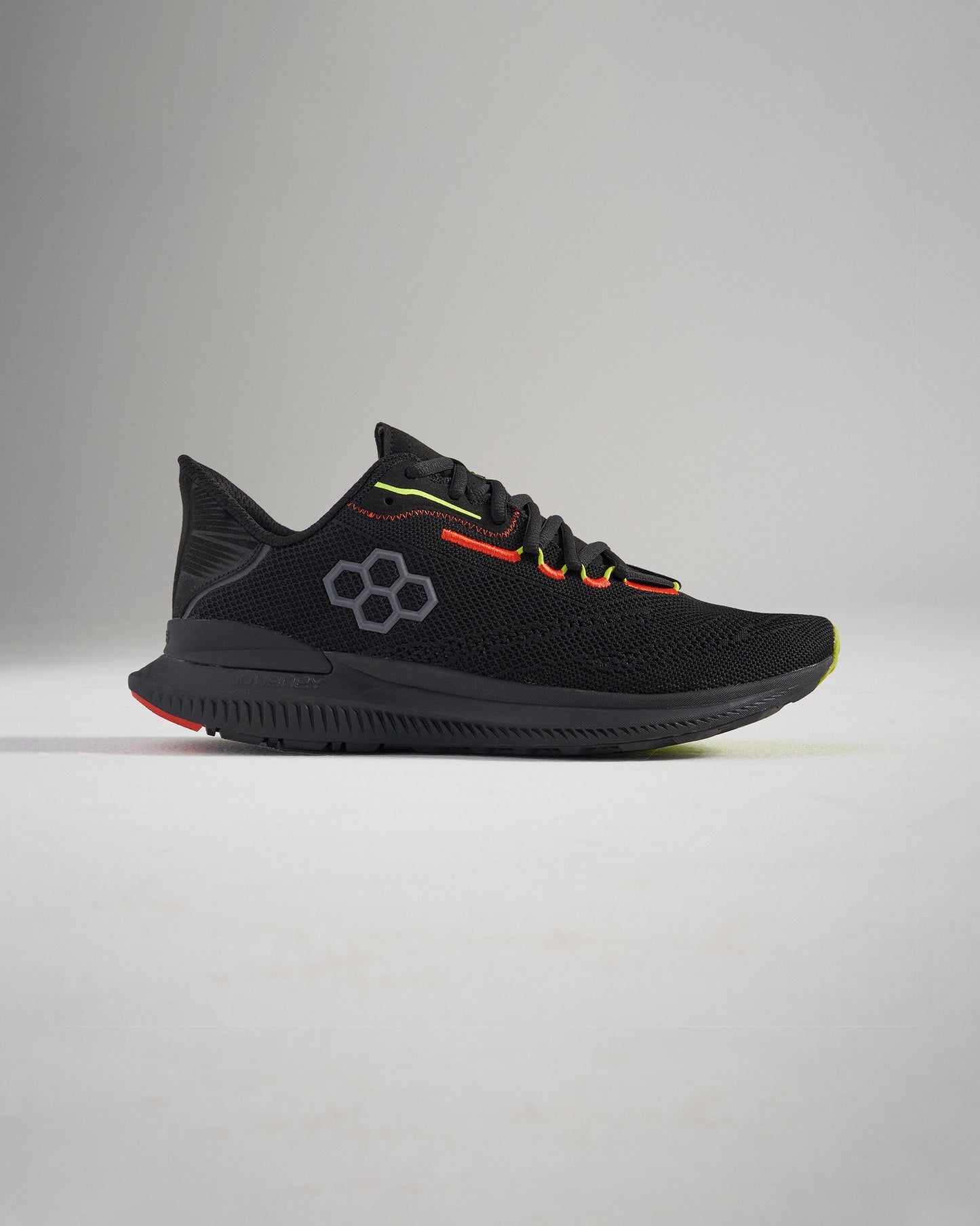 A sleek pair of black running shoes with dynamic red and yellow accents featuring a breathable mesh upper and textured sole for enhanced grip