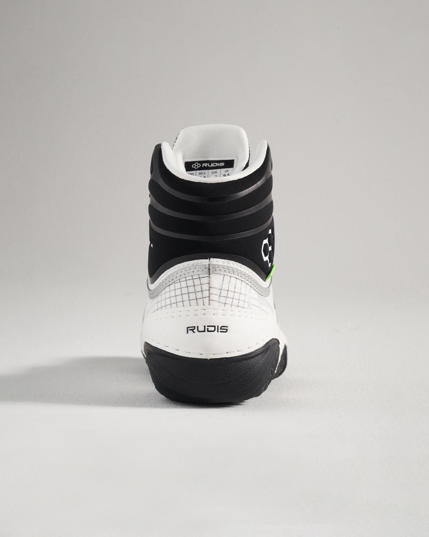 This image displays the back view of a white and black wrestling shoe with detailed design elements and branding