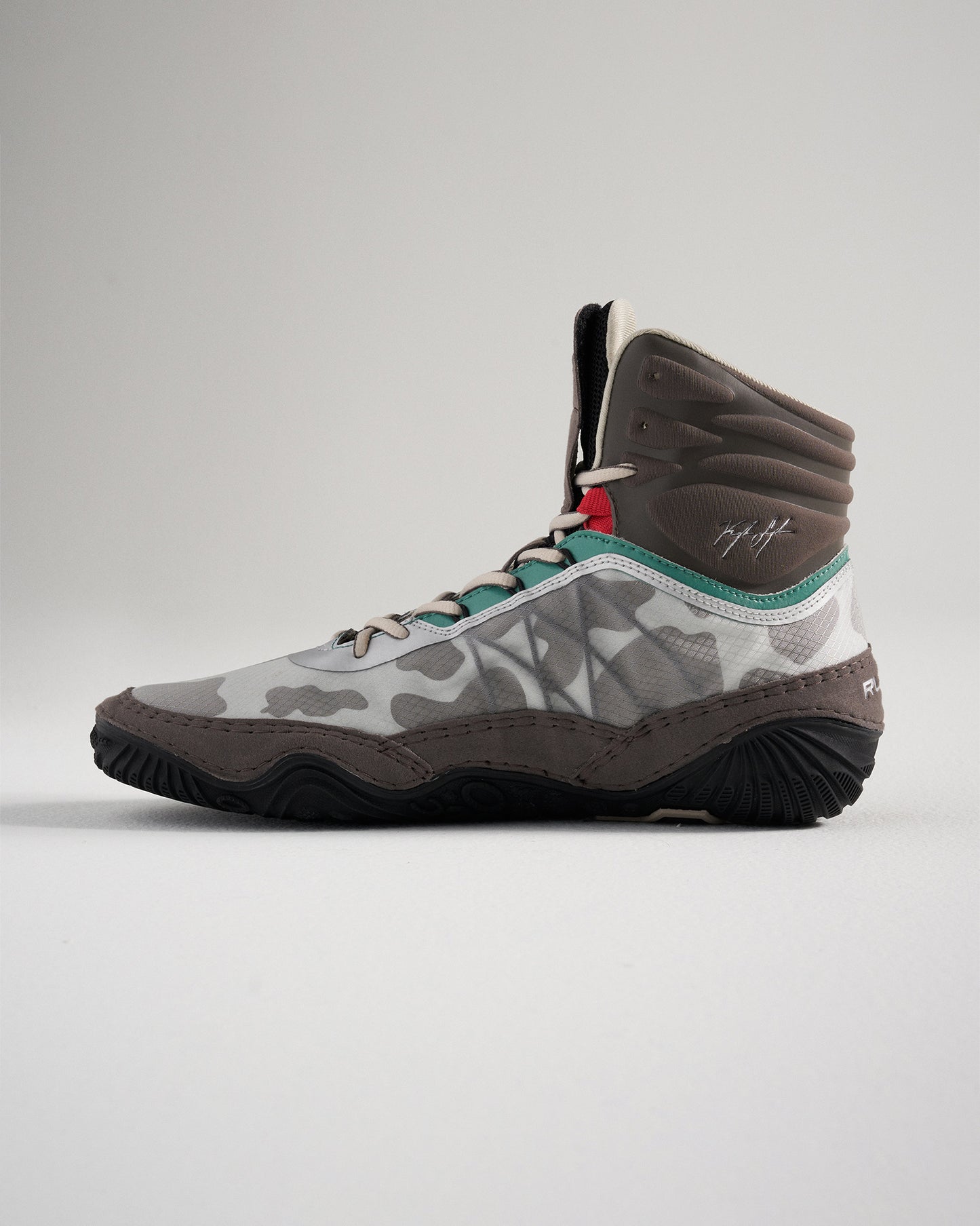 A stylish high-top sneaker featuring a unique gray camouflage pattern vibrant teal and red accents and a robust sole designed for performance