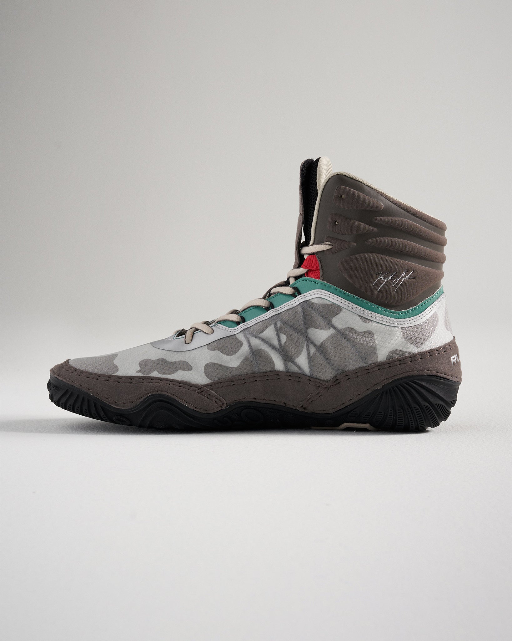 A stylish high-top sneaker featuring a unique gray camouflage pattern vibrant teal and red accents and a robust sole designed for performance
