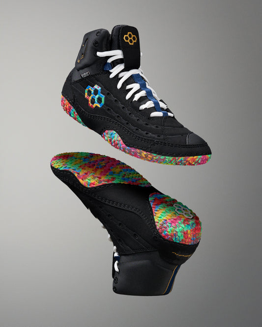 Black wrestling shoe with colorful sole on a gray background
