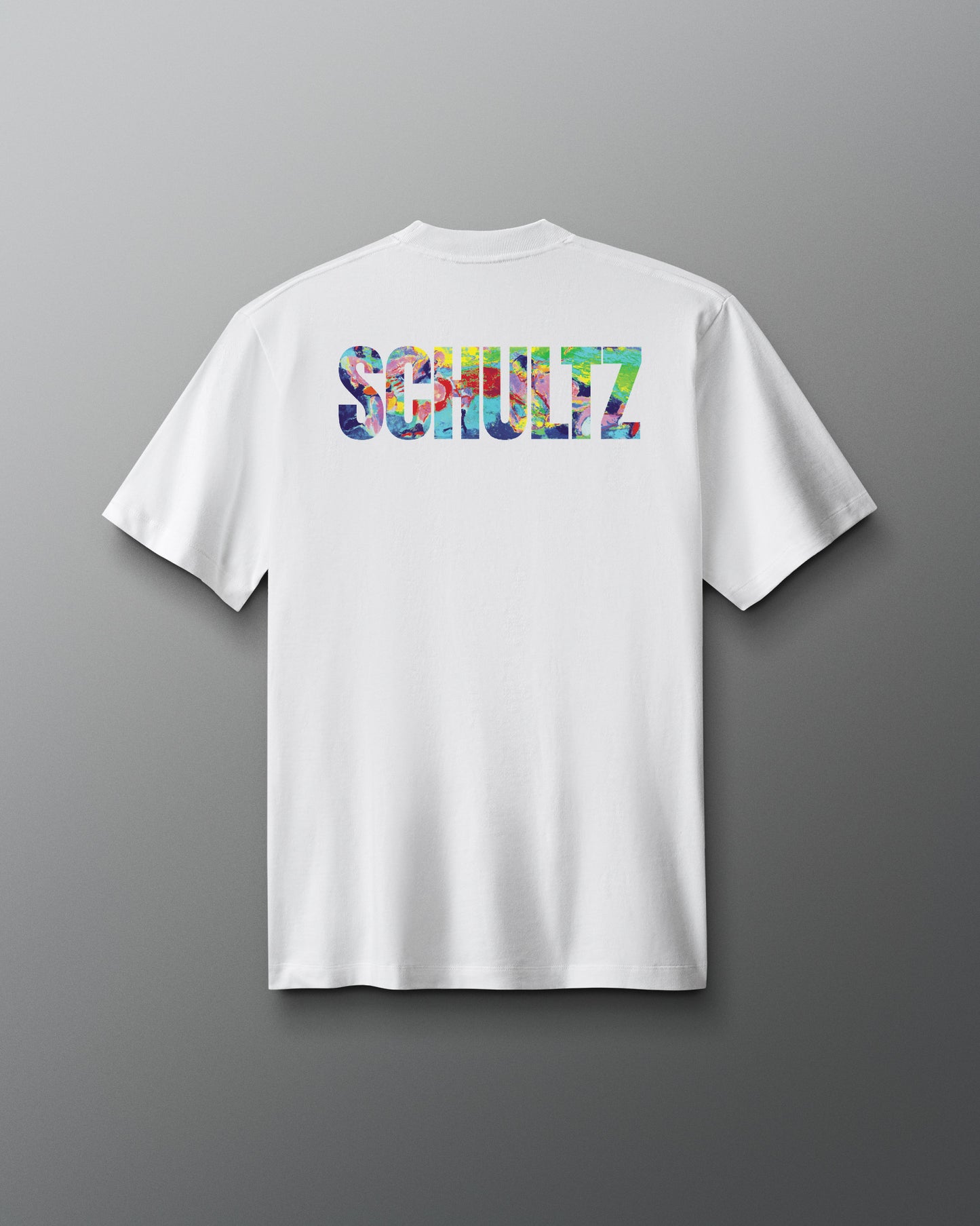White t-shirt with colorful 'SCHULTZ' logo on the back against a gray background