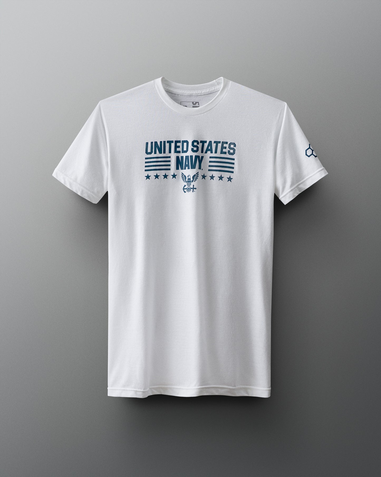 Front view of a white RUDIS T-shirt with bold blue text reading ‘United States Navy’ above an eagle insignia, with stars and horizontal lines in a military-style layout. RUDIS hexagon logo appears on the left sleeve.