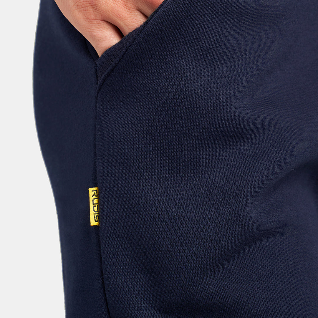 Close-up of navy sweatpants showcasing a pocket with a yellow brand tag emphasizing comfort and casual style
