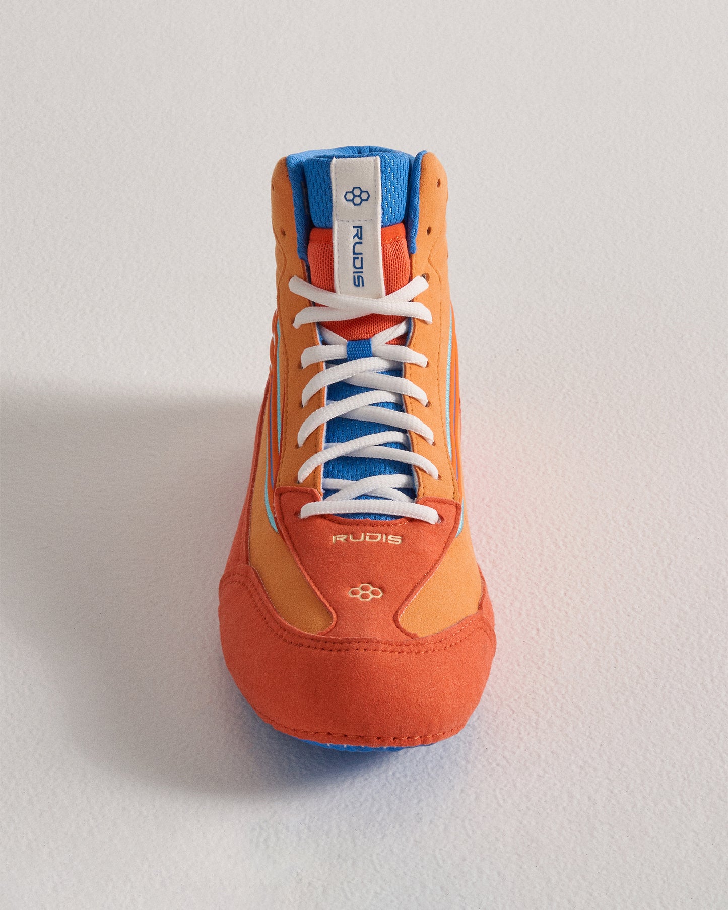 Front view of a wrestling shoe featuring a vibrant orange and blue color scheme with a textured sole and prominent lacing system