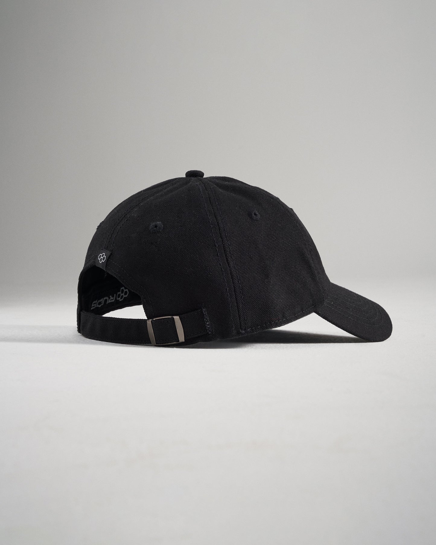 A stylish black baseball cap featuring a soft fabric finish and an adjustable strap at the back for a comfortable fit