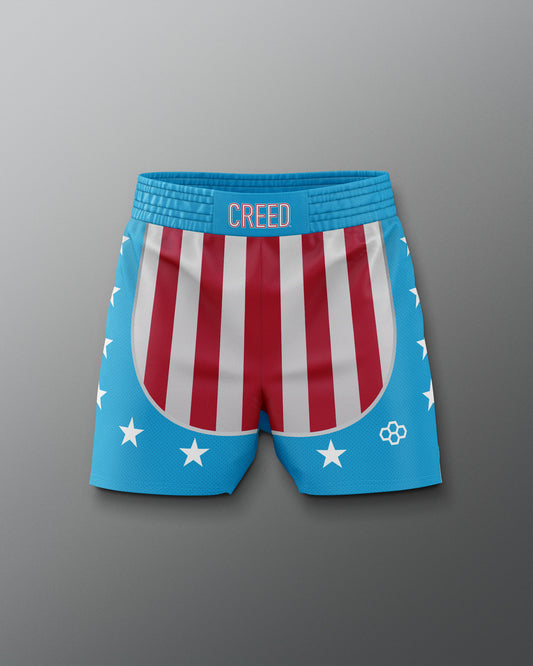 Front view of the Apollo Creed boxing training shorts, featuring red and white vertical stripes on the front, blue sides and waistband with white stars, and 'CREED' text centered on the waistband, inspired by the iconic Rocky movie look.