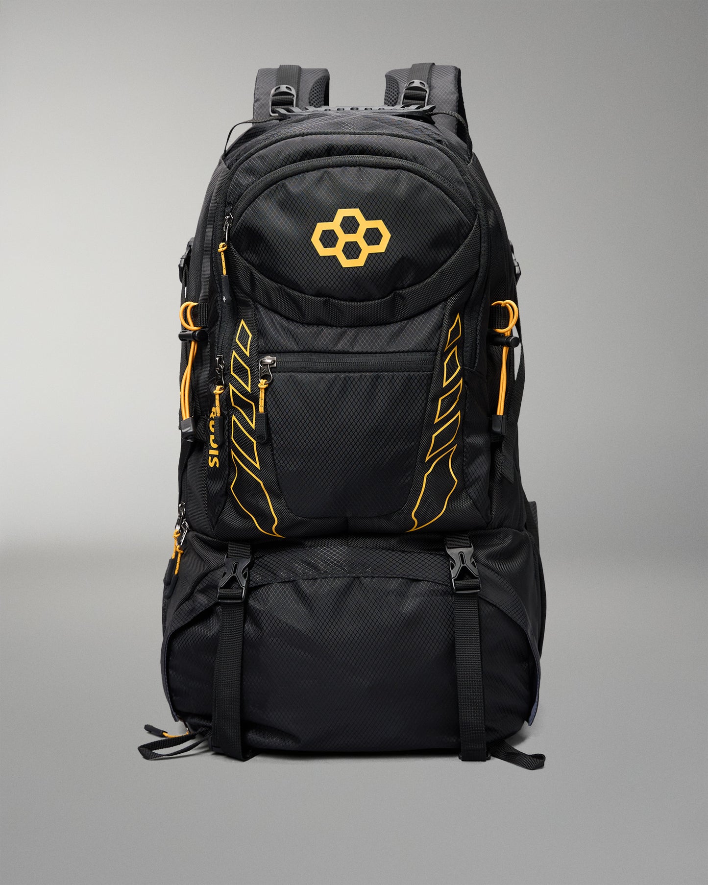 A black technical backpack with bright orange accents, including a geometric logo on the front pocket and vertical branding details, shown against a neutral gray background.