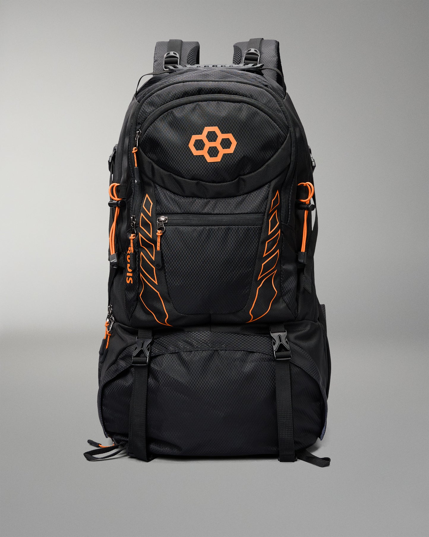 A black technical backpack with bright orange accents, including a geometric logo on the front pocket and vertical branding details, shown against a neutral gray background.