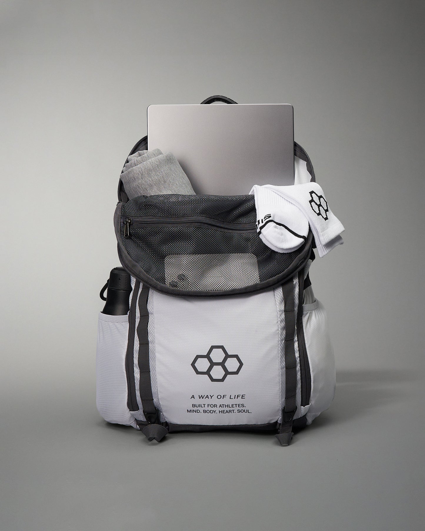A stylish athletic backpack filled with gym clothes socks and a laptop featuring a motivational phrase
