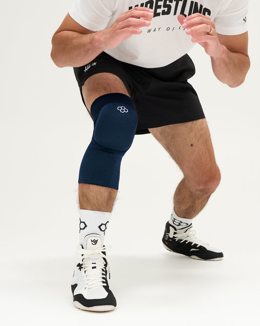 Person wearing a navy knee pad on a white background
