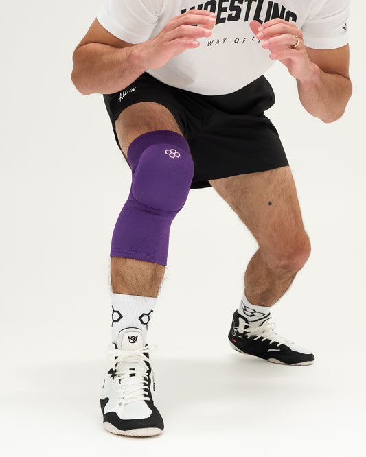 Person wearing a purple knee pad on a white background