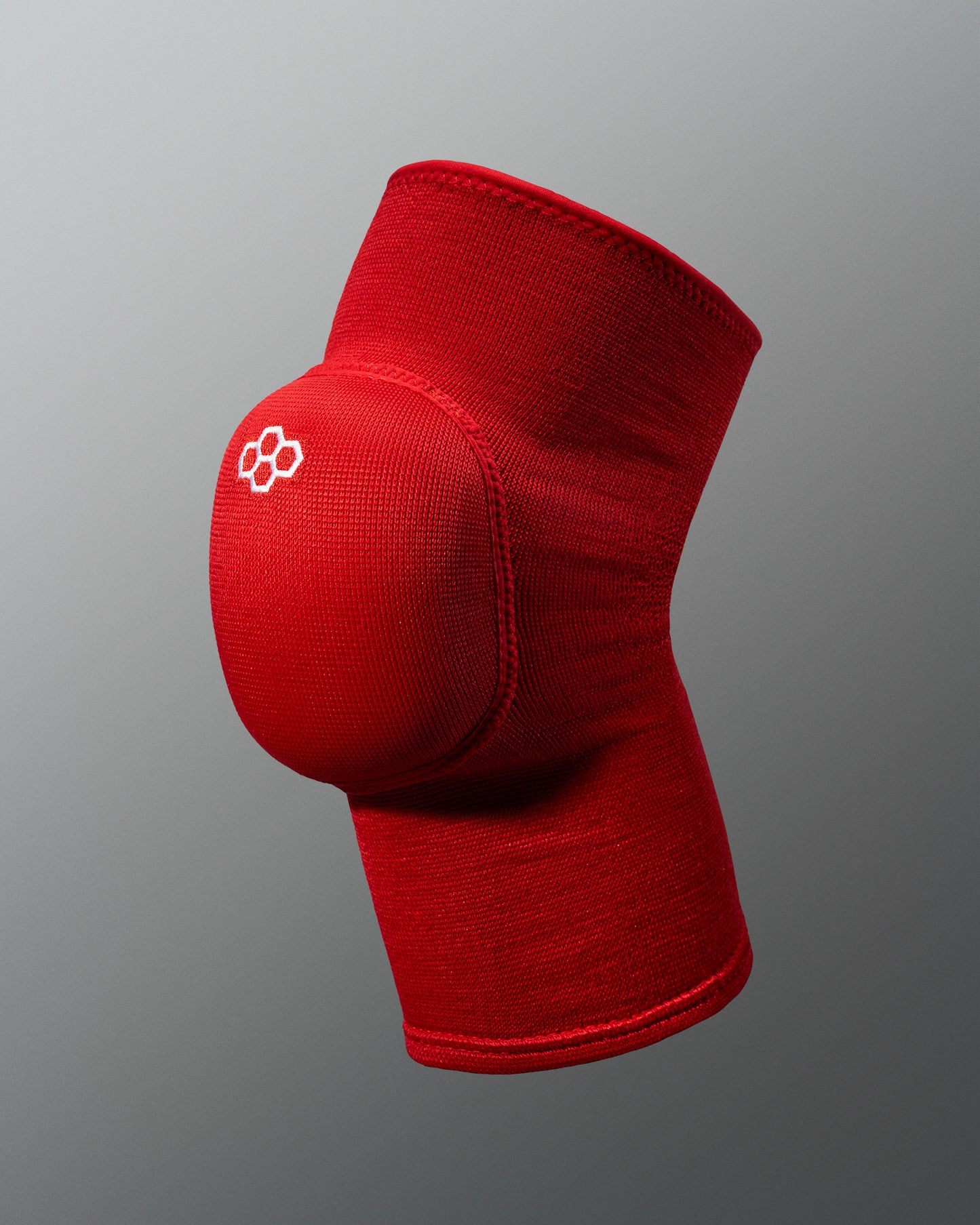 A vibrant red wrestling knee pad featuring a padded support area designed for athletic use and injury prevention