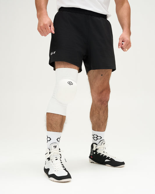 Person wearing a white knee pad on a plain background