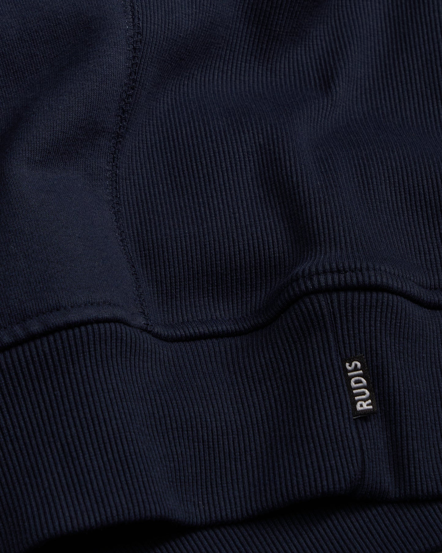 Navy blue sweatshirt with 'RUDIS' logo on the chest pocket