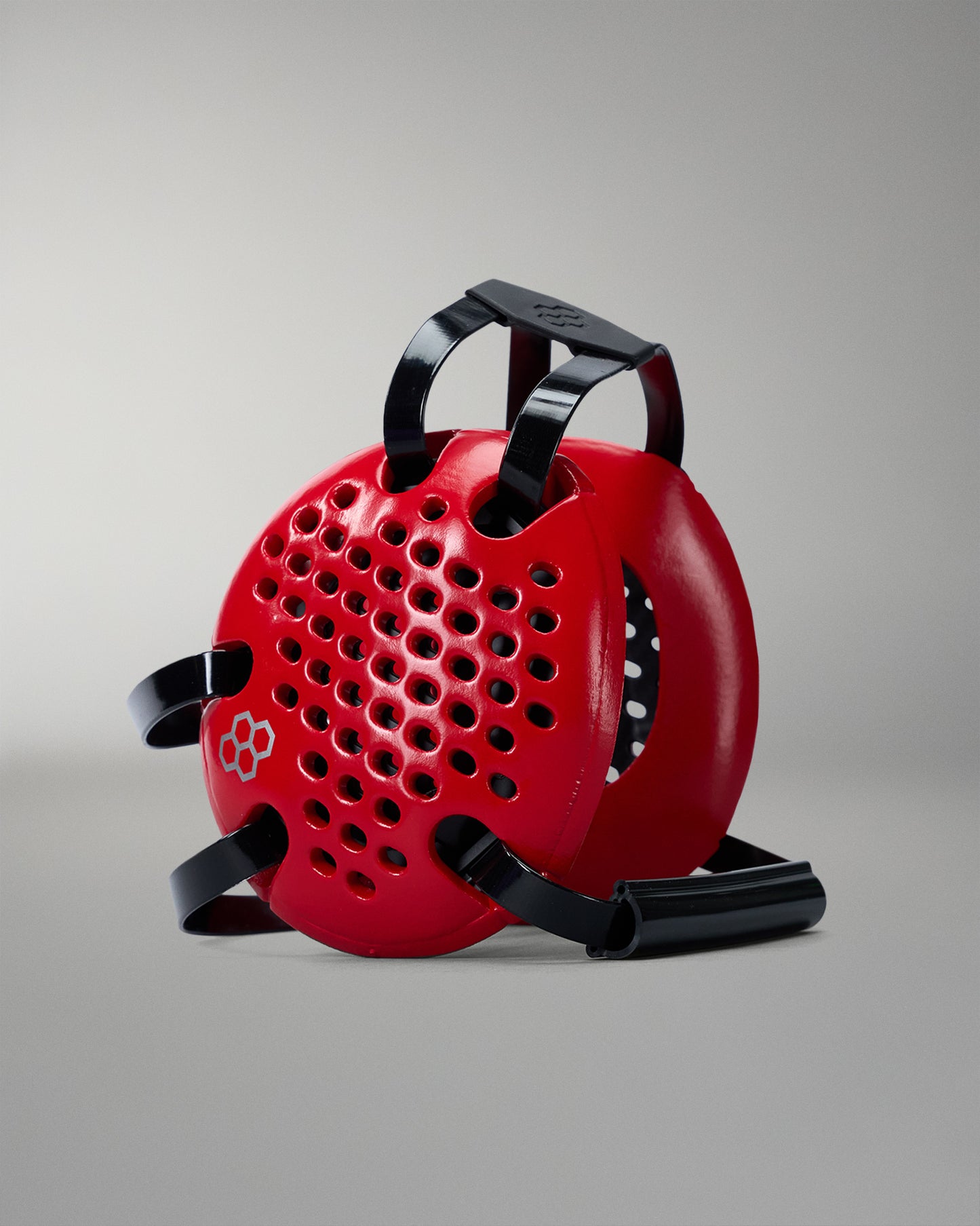 Red reel with black handle and straps on a gray background