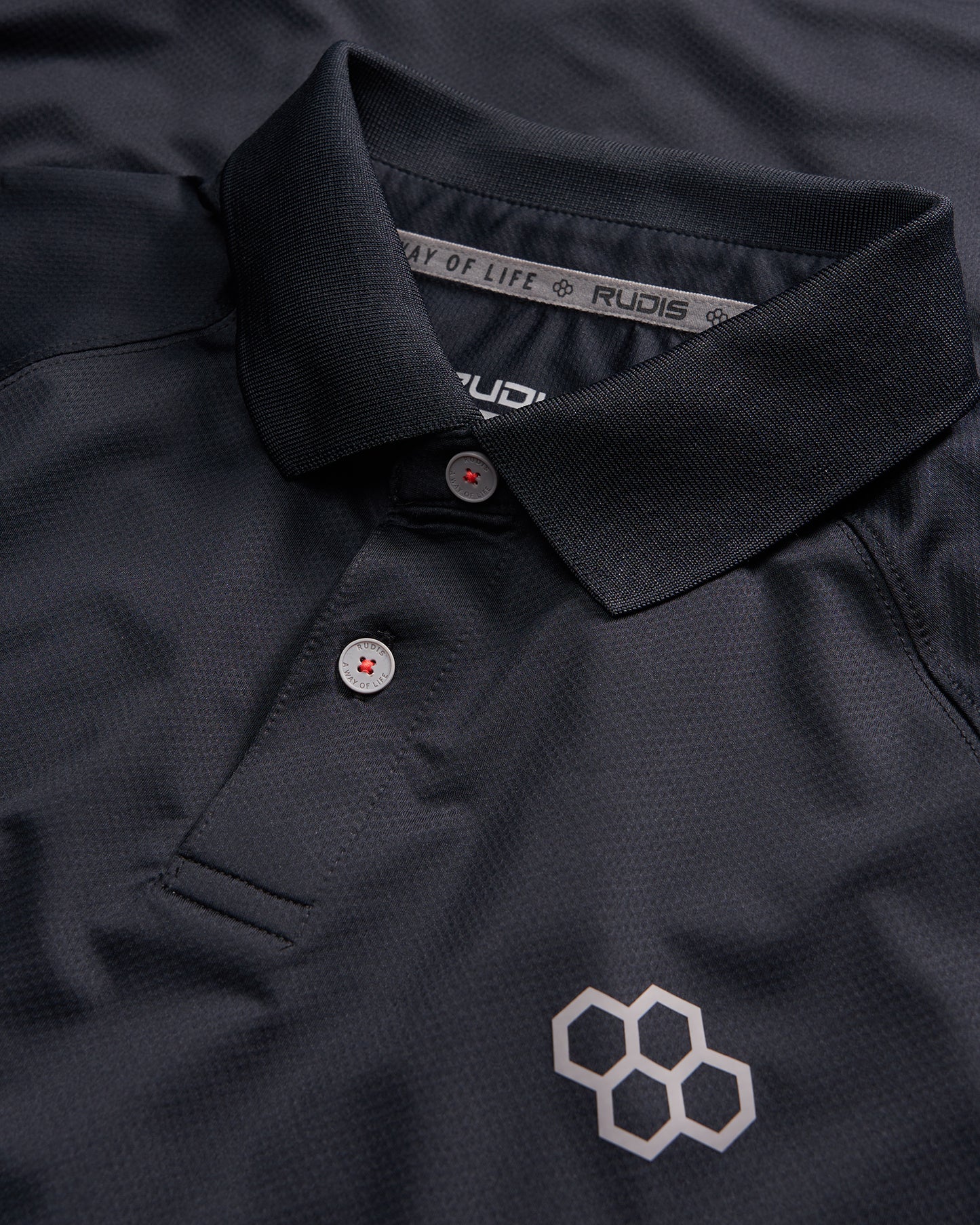 A close-up view of a black polo shirt featuring a classic collar two buttons and a geometric logo in a contrasting shade