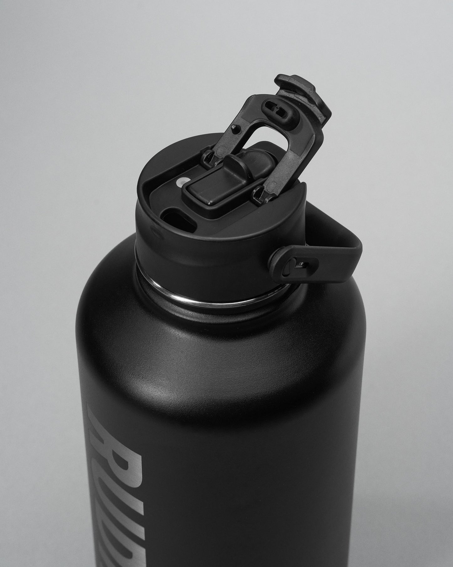 Black water bottle with a screw-on cap on a light gray background