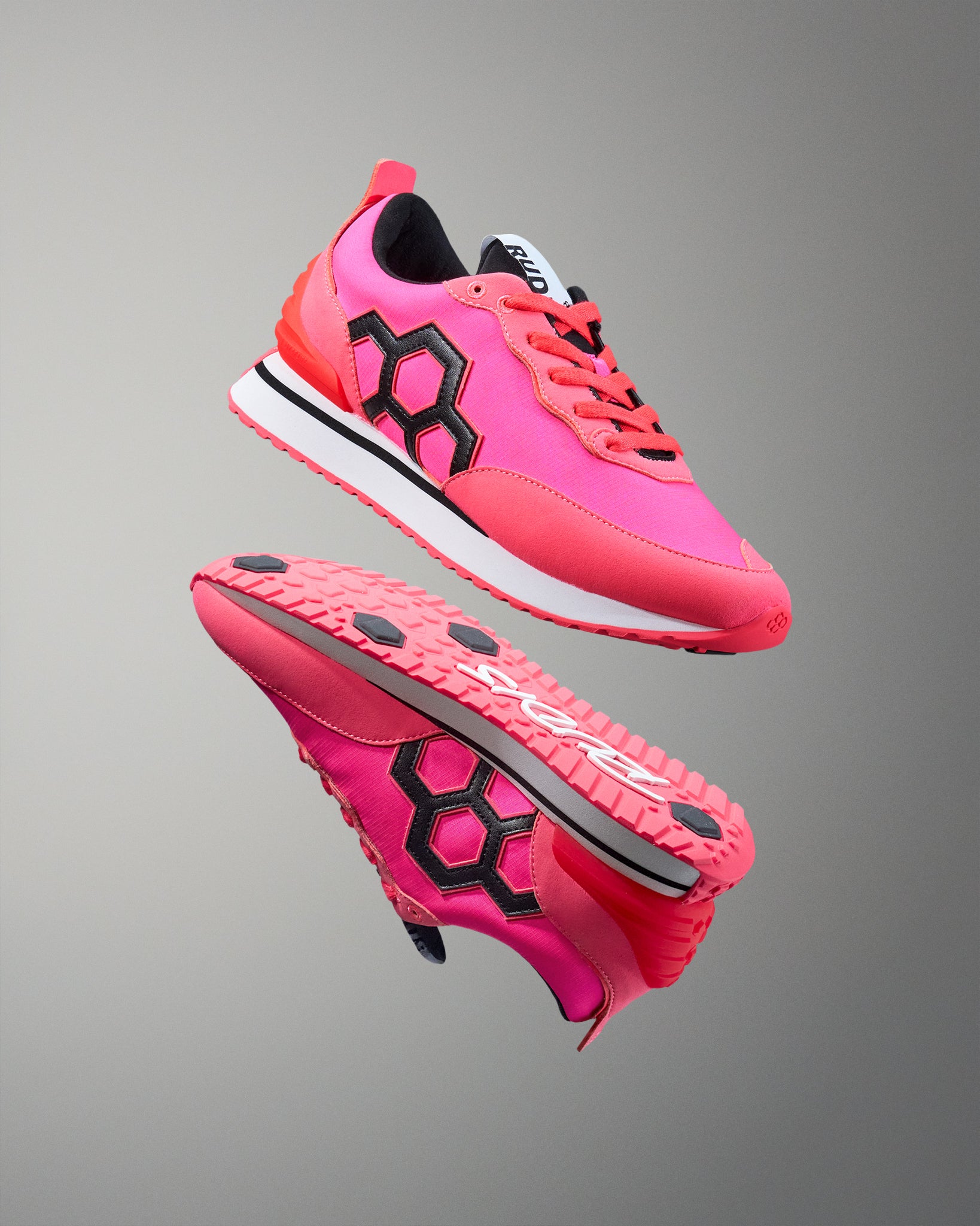Pink and black athletic shoes on a gray background