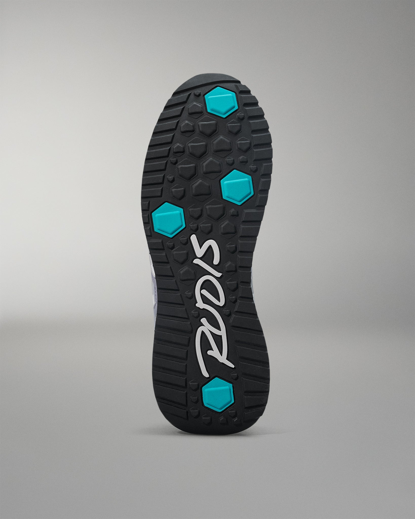 Black shoe sole with blue hexagonal patterns and 'Puma' branding on a gray background