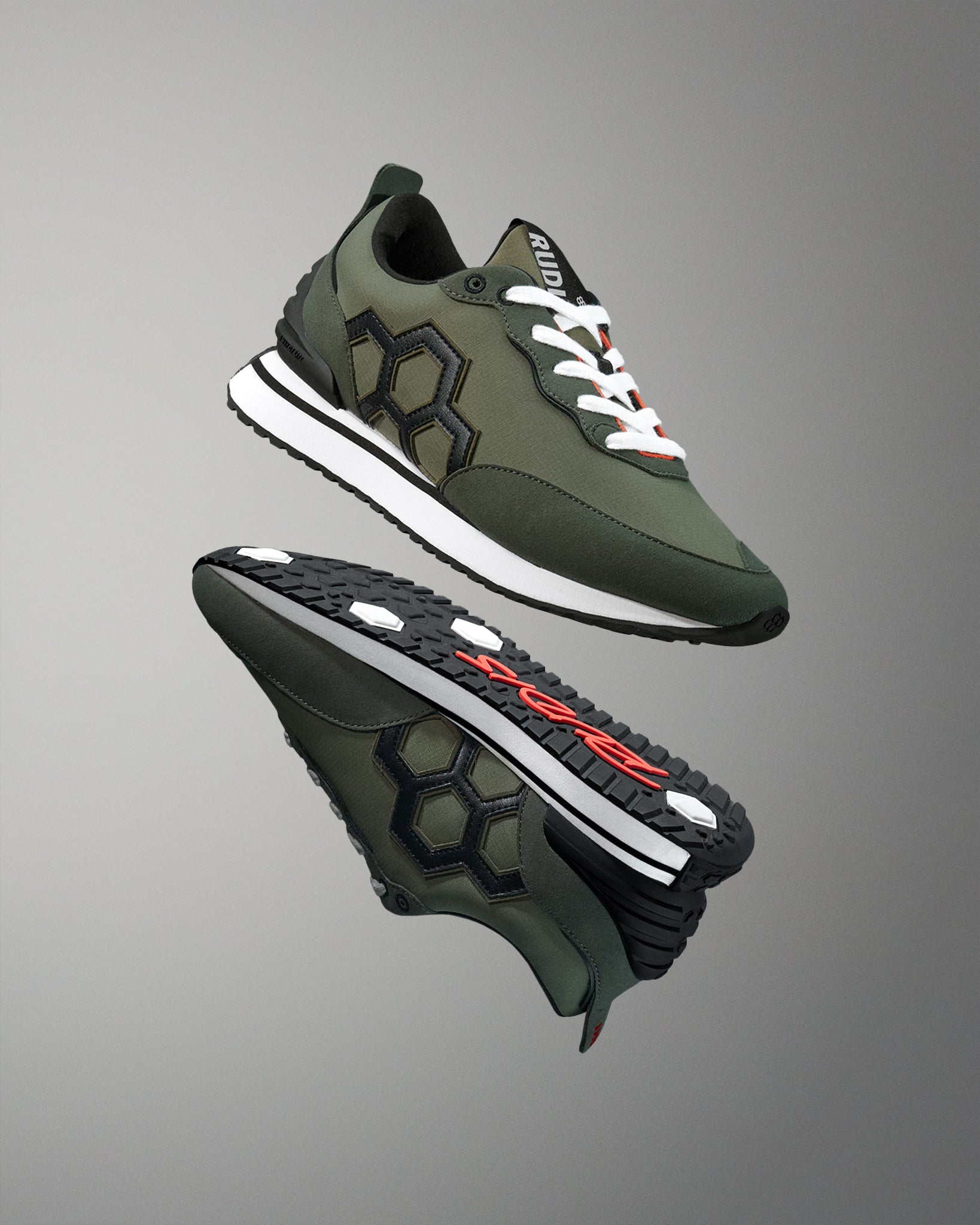 Green and black athletic shoes with white laces on a gray background