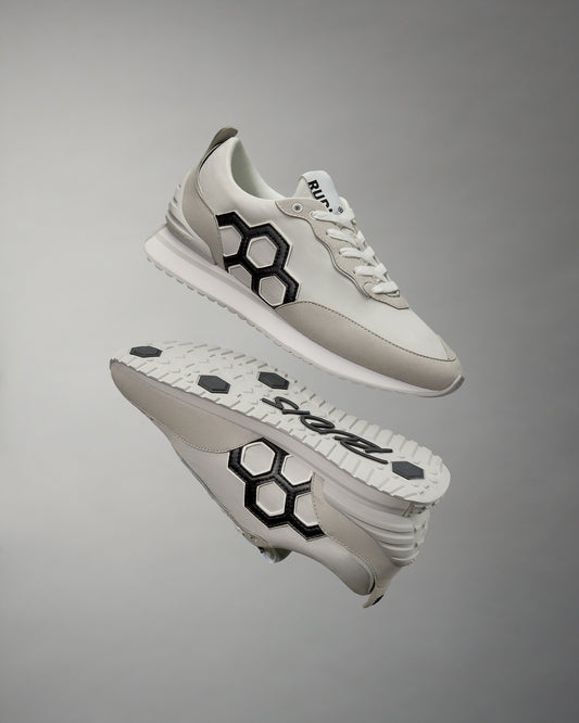 A pair of white RUDIS Street Adult Lifestyle Shoes with a large black hex logo on the side, displayed against a grey background.