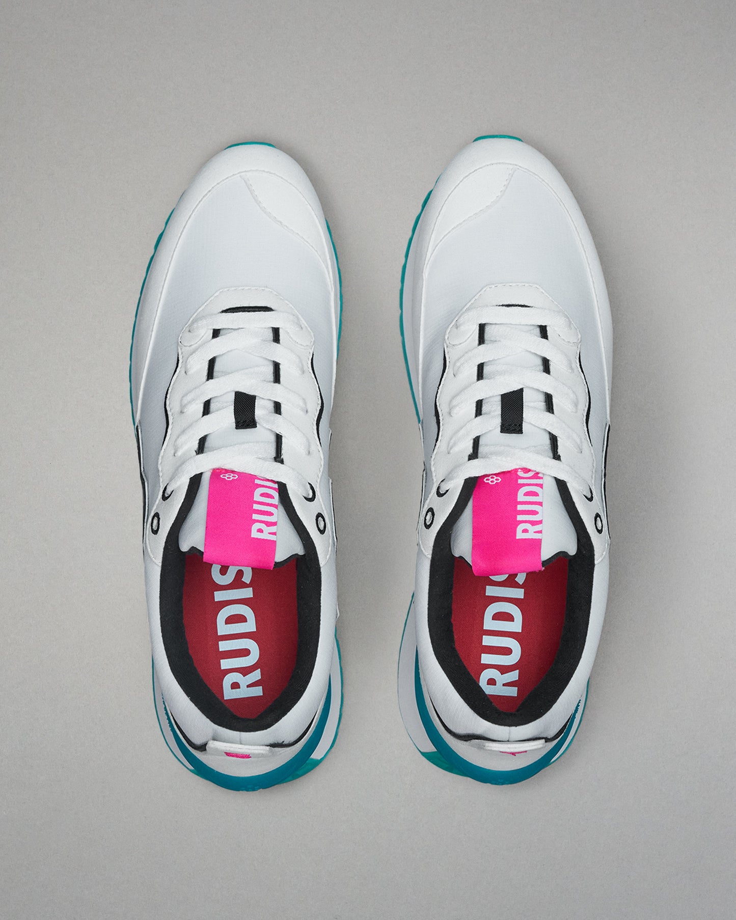 White sneakers with black and red accents on a gray background